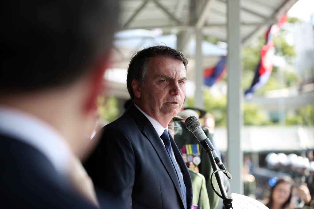 Retrato de Jair Bolsonaro em plano médio, vestindo terno escuro e gravata.