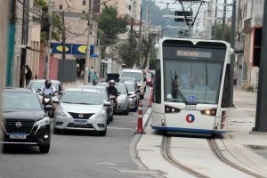 Carros e motos dirigindo ao lado da linha 2 do VLT em Santos