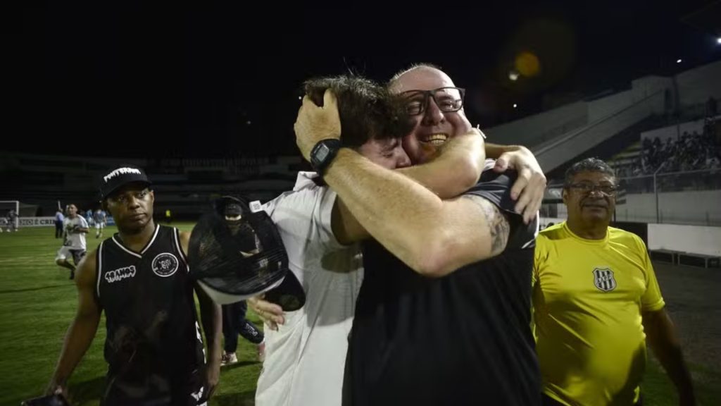 Torcedor abraçando o treinador Marcelo Teixeira após a vitória da Ponte Preta na final da série C