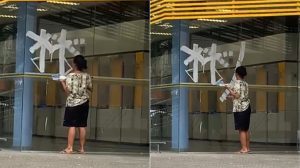 Moradora de rua é flagrada desenhando asteriscos na porta de banco em São Vicente; VÍDEO