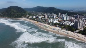 Vista aérea da orla de Guarujá, destacando a praia que venceu o prêmio Top Destinos Turísticos 2025.