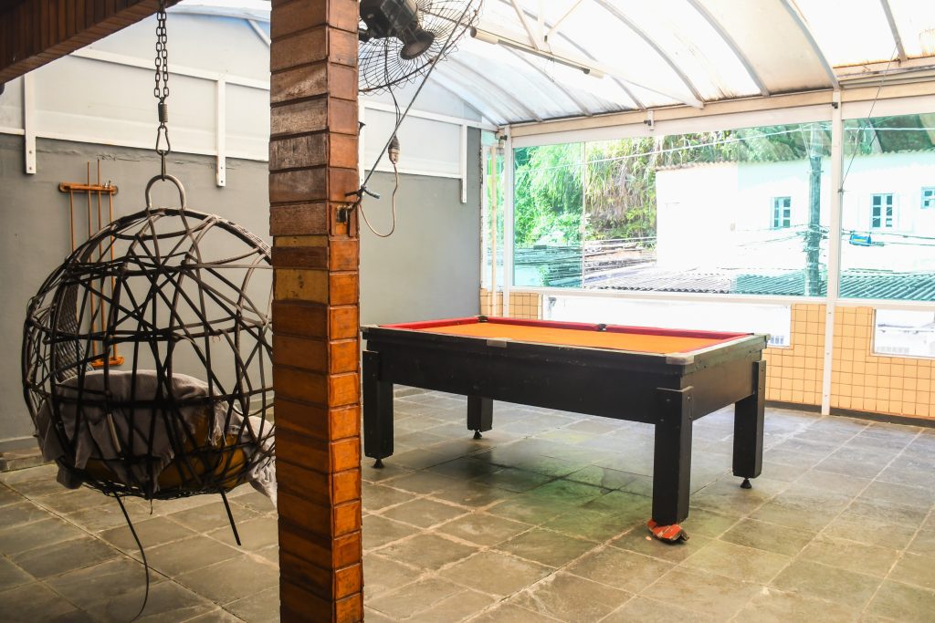 Sala de convivência e lazer do Espaço Novo Começo em São Vicente, com sofás e ambiente decorado para os jovens.