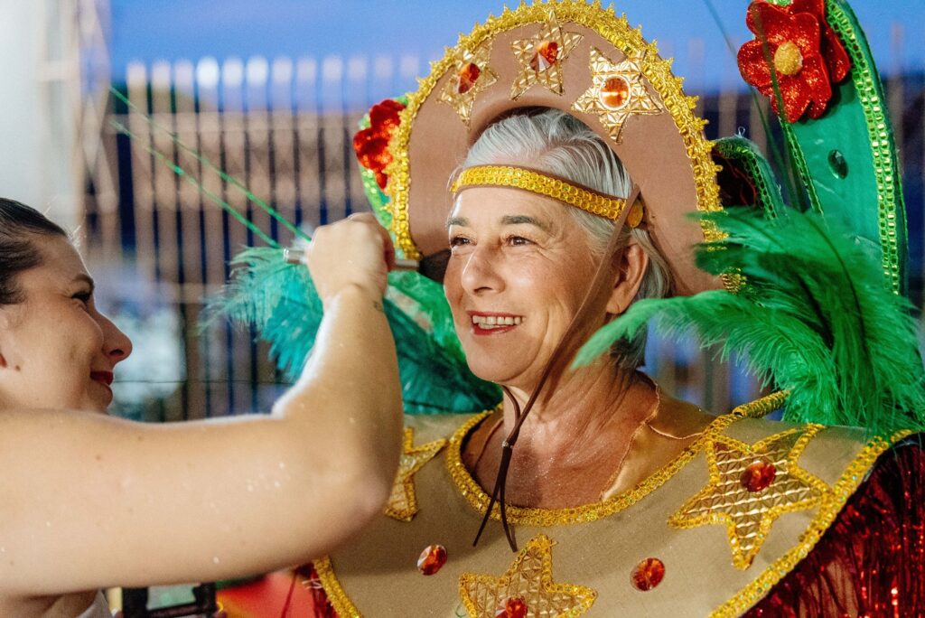 Pessoas celebrando o Carnaval 2026 de Piracicaba no Engenho Central com adereços coloridos e clima festivo.