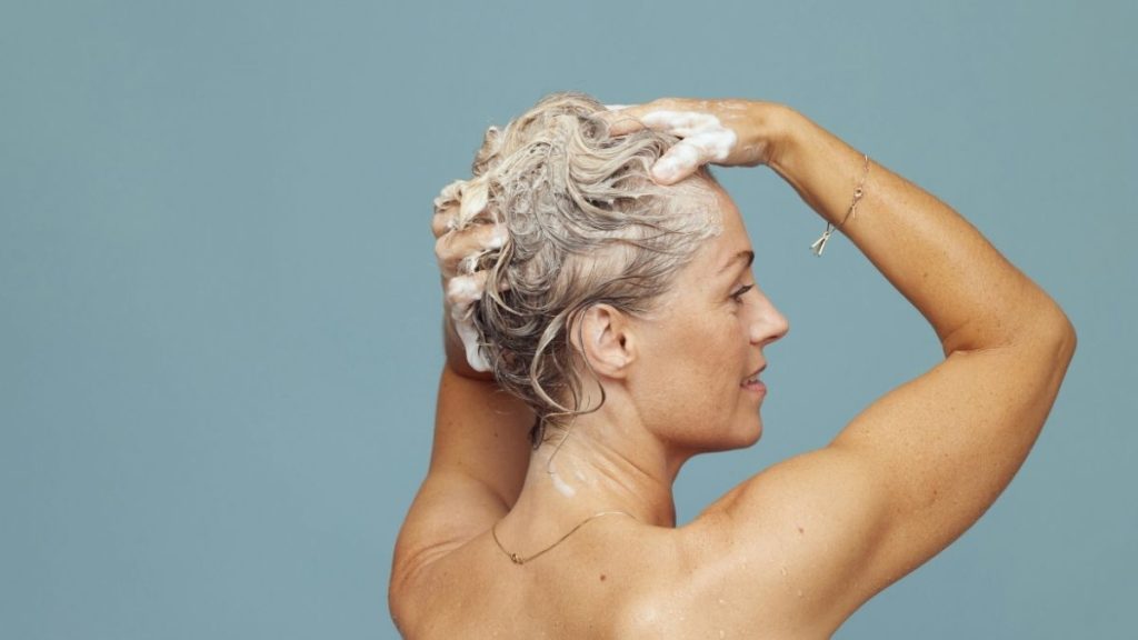 Pessoa em um banheiro demonstrando dúvida sobre a frequência ideal e os efeitos de ficar sem tomar banho.