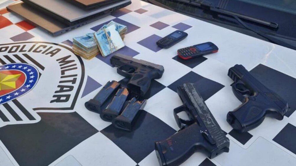 Armas de fogo e munições apreendidas pela Polícia Militar dispostas sobre mesa durante a Operação Keravnos.