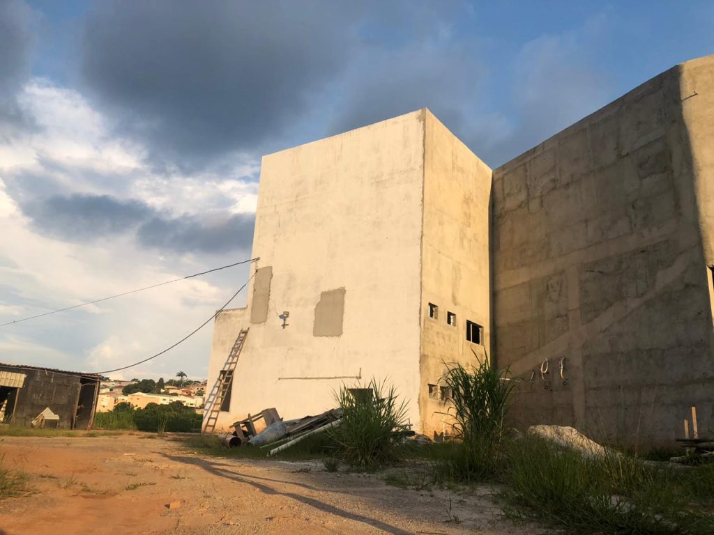 Parede com pintura incompleta e ausência de pisos instalados na construção da Câmara Municipal.