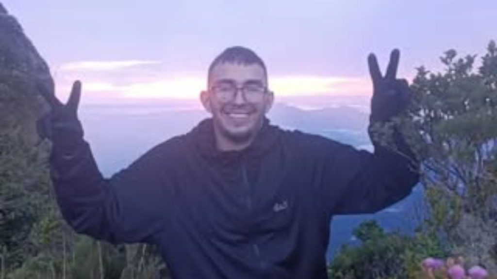 Roberto Farias Tomaz posando para foto em meio à vegetação durante trilha no Pico do Paraná.