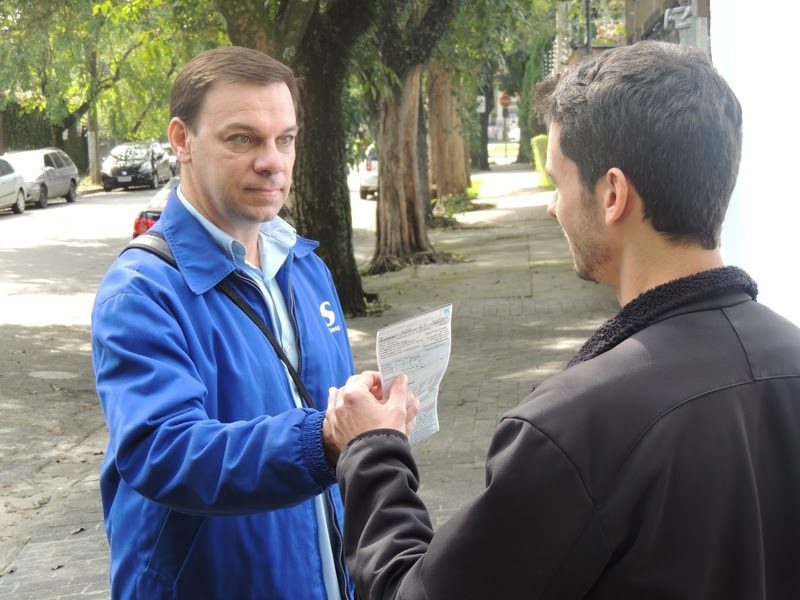 Atendente da Sabesp orienta consumidor em balcão de atendimento durante negociação de dívidas Sabesp.