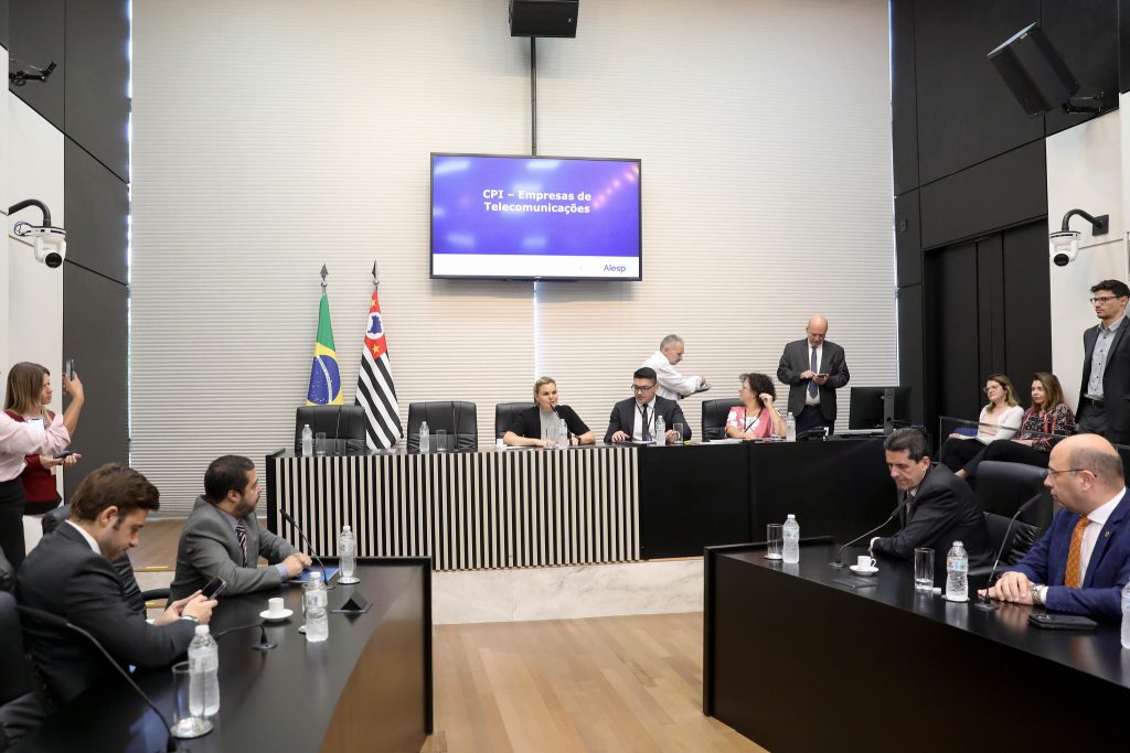 Parlamentares reunidos em mesa de comissão durante a CPI da Empresa de Telecomunicações na Alesp.