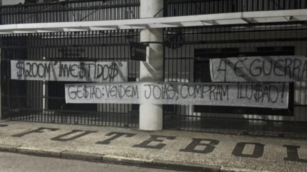 Faixa de protesto da torcida do Santos estendida em grade na rua durante a madrugada na Vila Belmiro.