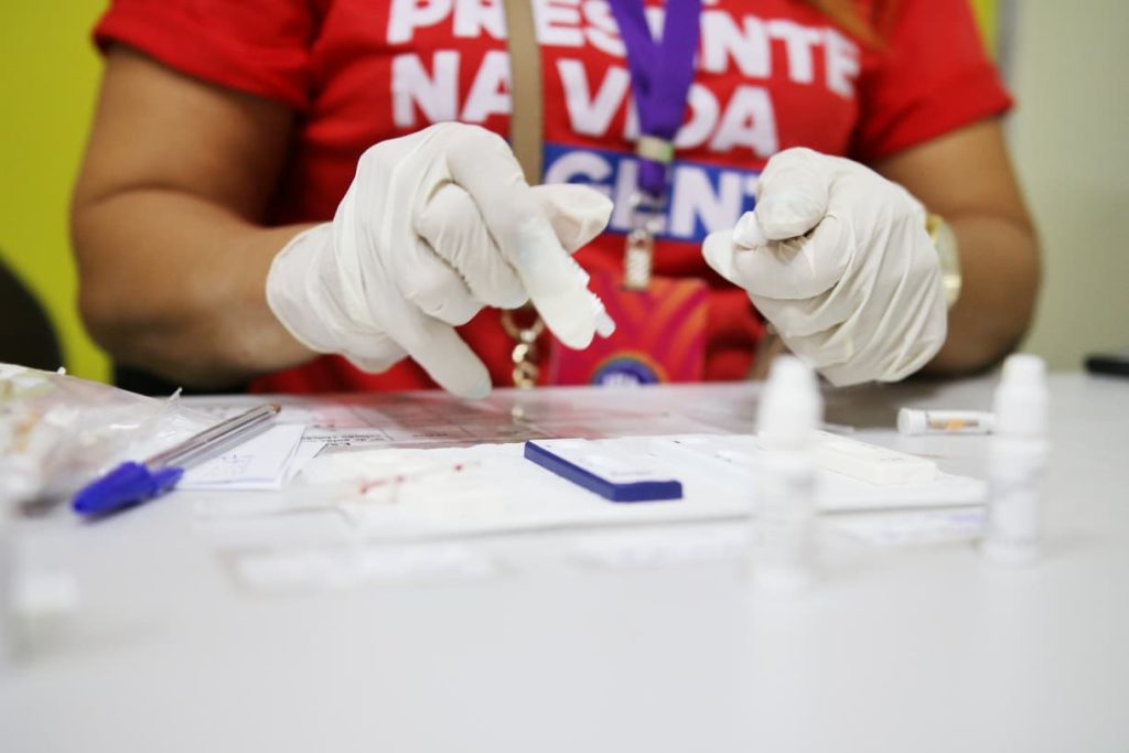 Posto de saúde no Carnaval oferecendo testes rápidos de ISTs e orientações preventivas contra doenças transmissíveis.