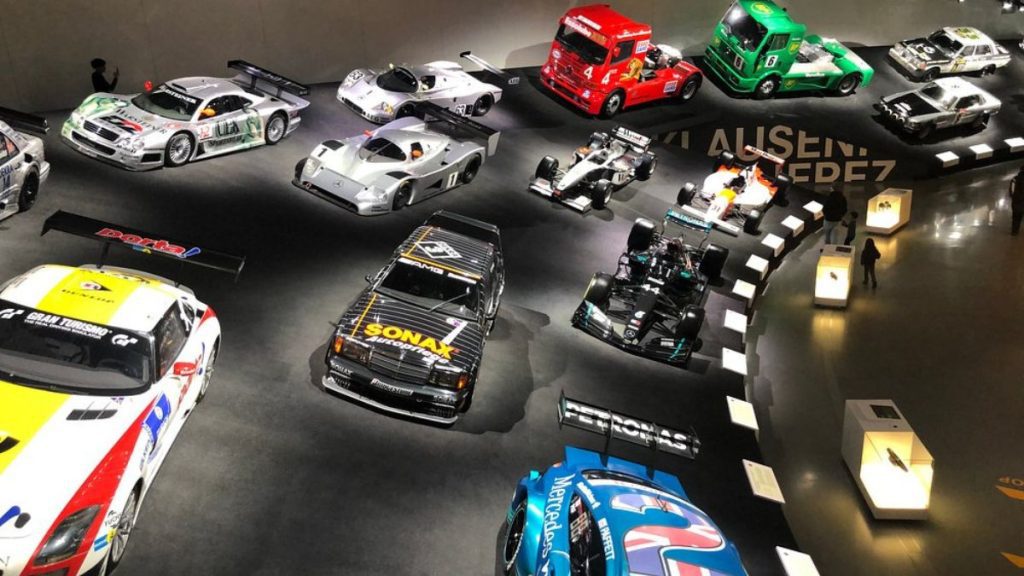 Exposição cronológica no Museu Mercedes-Benz ilustrando a evolução tecnológica e a paixão por carros desde a invenção.