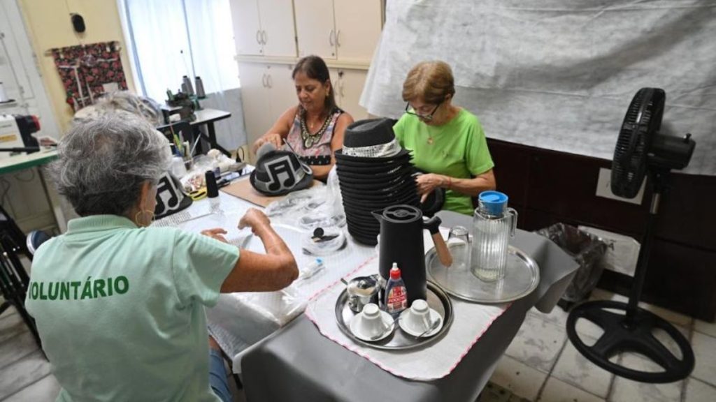 Voluntárias do FSS Santos confeccionando fantasias de época com brilho e detalhes para o desfile do Carnabonde.