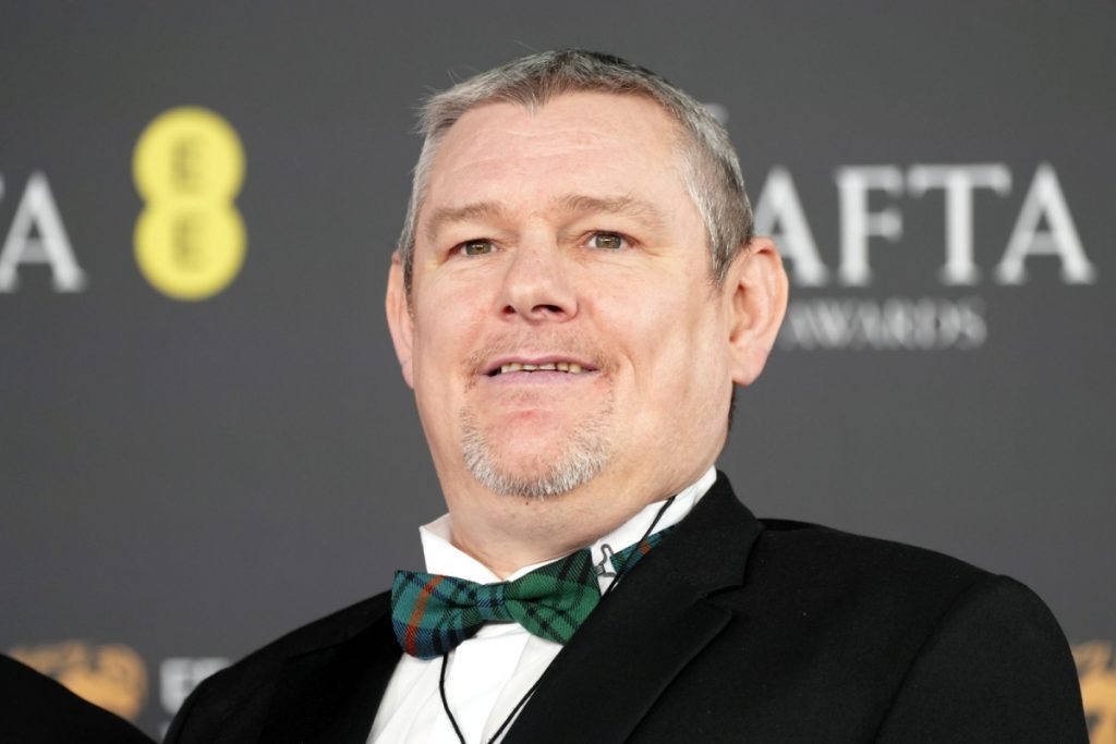 John Davidson, convidado com síndrome de Tourette, em foco após polêmica de insulto racial na cerimônia Bafta 2026.