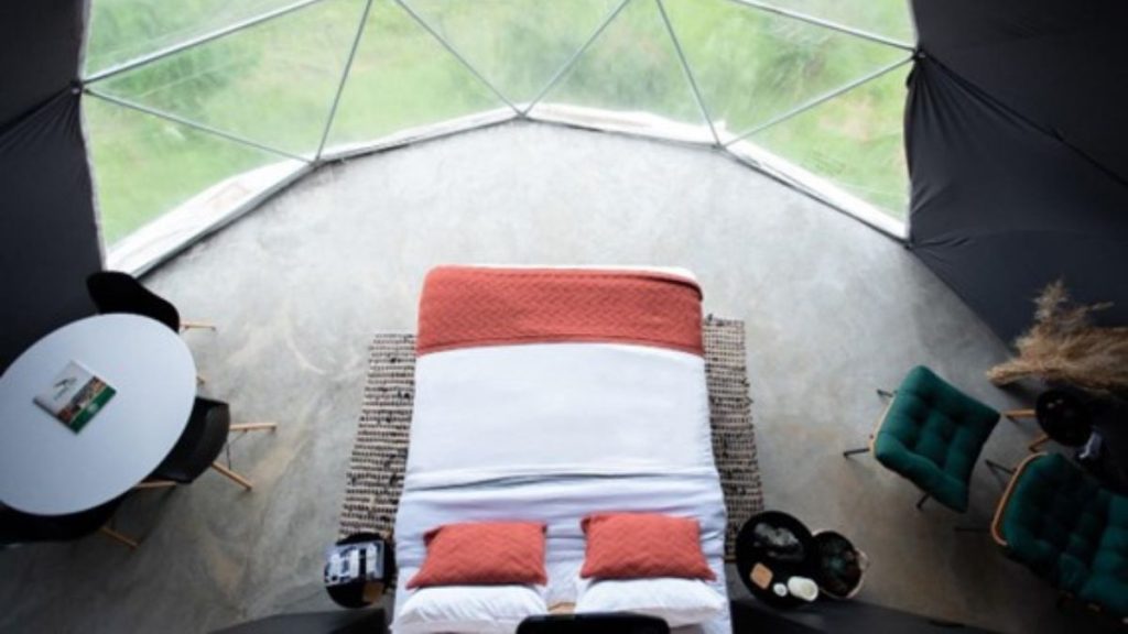 Glamping no Brasil com hidromassagem panorâmica e área de fogueira sob o céu estrelado.