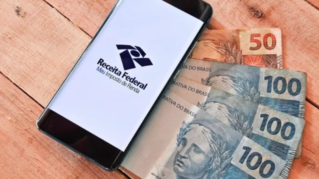 Documentos fiscais e calculadora organizados para o preenchimento da declaração do Imposto de Renda 2026.