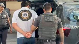 Policiais em estádio de futebol utilizando tecnologia de reconhecimento facial do programa Muralha Paulista para prisões.