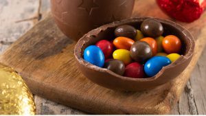 Crianças atendidas pela Abraccii segurando ovos de chocolate na Campanha de Páscoa em Santos.