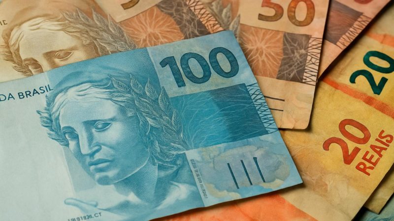 Trabalhador consultando calendário de pagamento do PIS/Pasep 2024 para nascidos em maio e junho no celular.