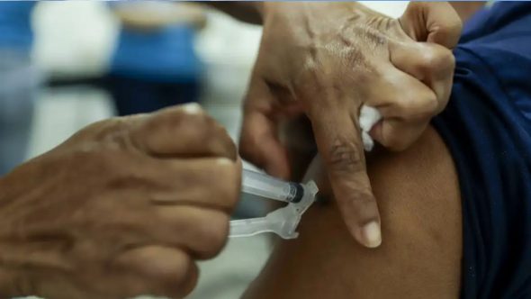 Profissional de saúde analisando dados do aumento de casos de Influenza A no Brasil segundo o Boletim InfoGripe.