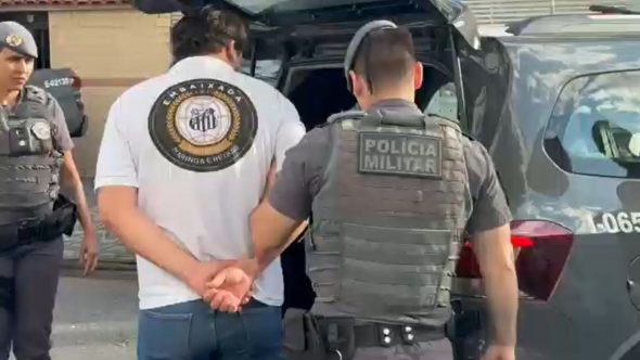 Policiais em estádio de futebol utilizando tecnologia de reconhecimento facial do programa Muralha Paulista para prisões.