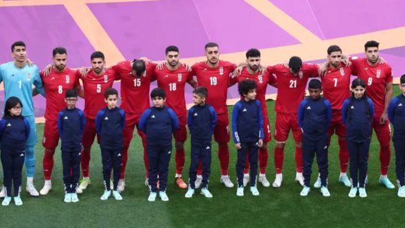 Jogadores da seleção de futebol do Irã em campo, representando a desistência do país da próxima Copa do Mundo.