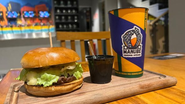 Evento Manube Day na Cervejaria Manube com copos de cerveja artesanal e experiência gastronômica em Santos.