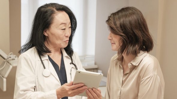 Profissional de saúde do SUS realiza atendimento em paciente durante mutirão de saúde da mulher.