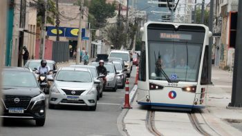 Carros e motos dirigindo ao lado da linha 2 do VLT em Santos