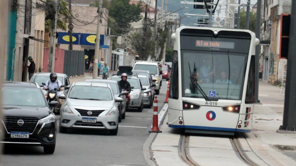 Carros e motos dirigindo ao lado da linha 2 do VLT em Santos