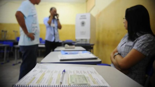 Mesário voluntário da Justiça Eleitoral em atendimento durante as Eleições Gerais de 2026.