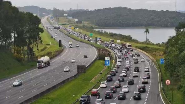 Manutenção no Sistema Anchieta-Imigrantes com sinalização de obras e fluxo de veículos em rodovia.