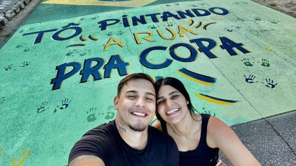 Influenciadora Lethicia Videira realizando pintura temática da Copa do Mundo em rua de Praia Grande.